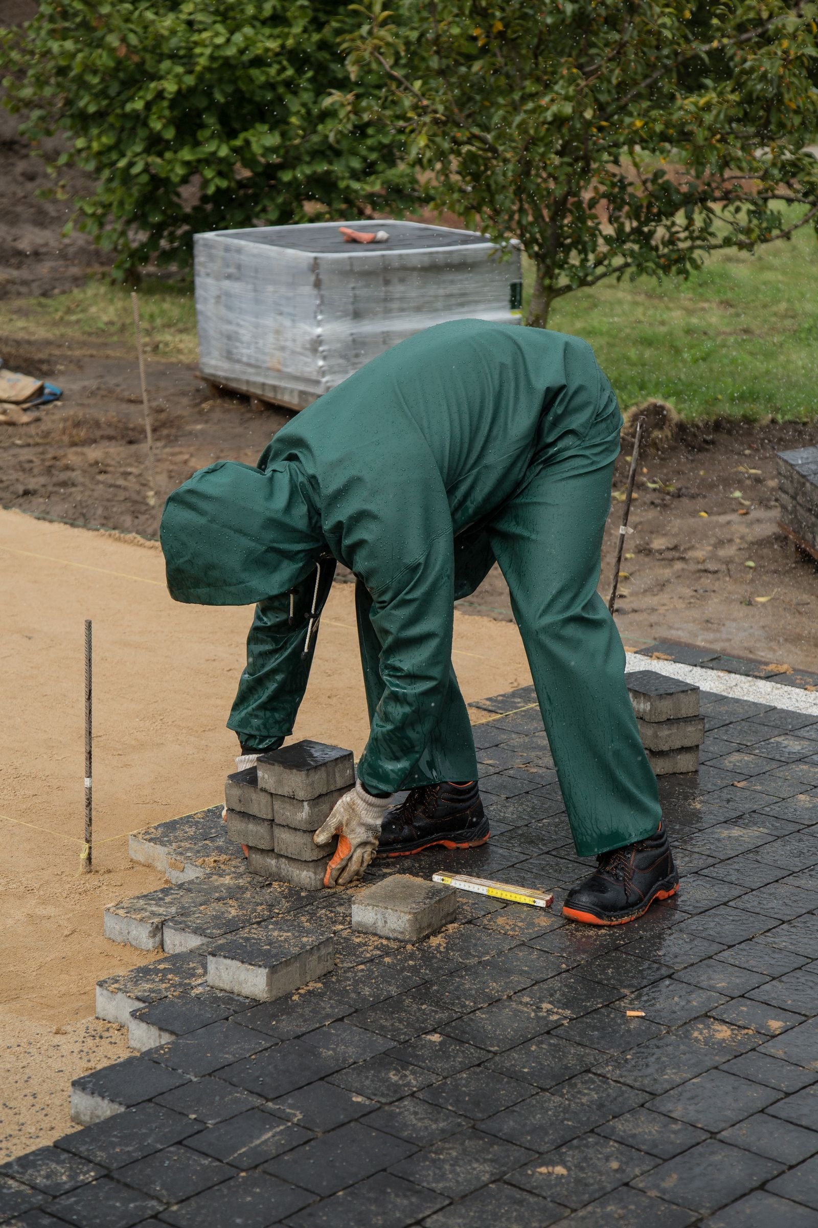 Installer laying pavers on a compacted base in Tampa Bay
